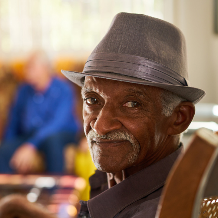 elderly African American male in a trilby hat seated